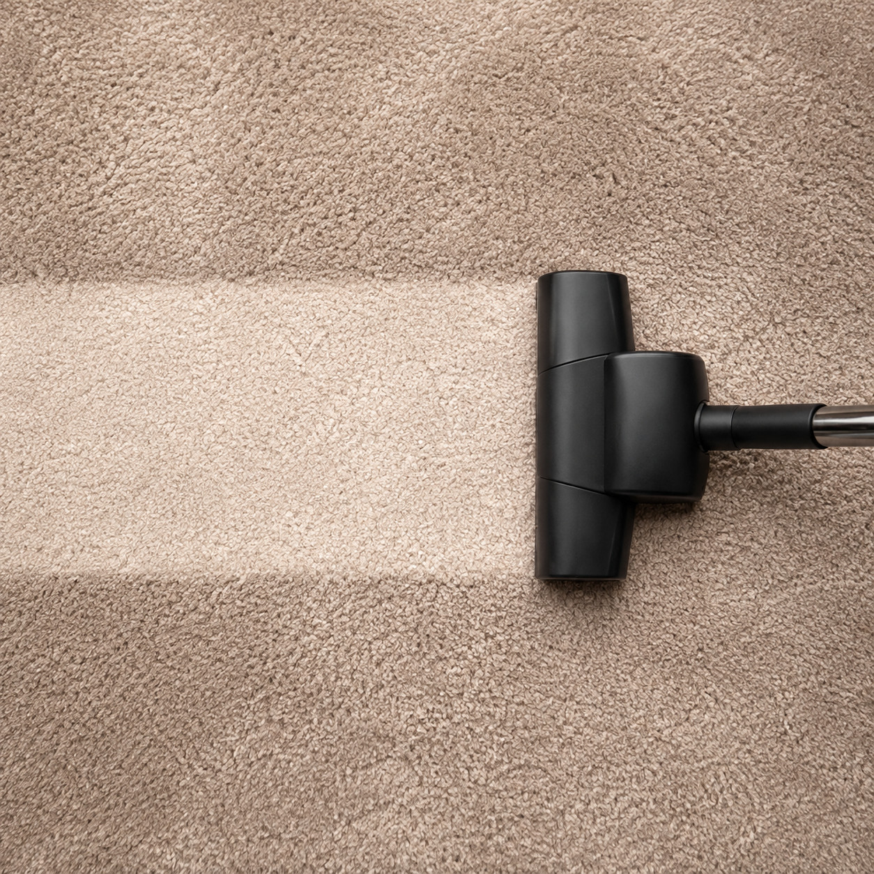 Vacuuming beige carpet as part of a daily care routine | McSwain Carpets & Floors
