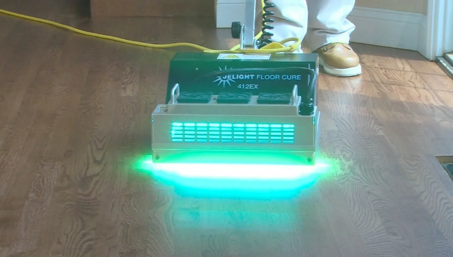 McSwain technician using the signature ultraviolet curing machine on a hardwood floor
