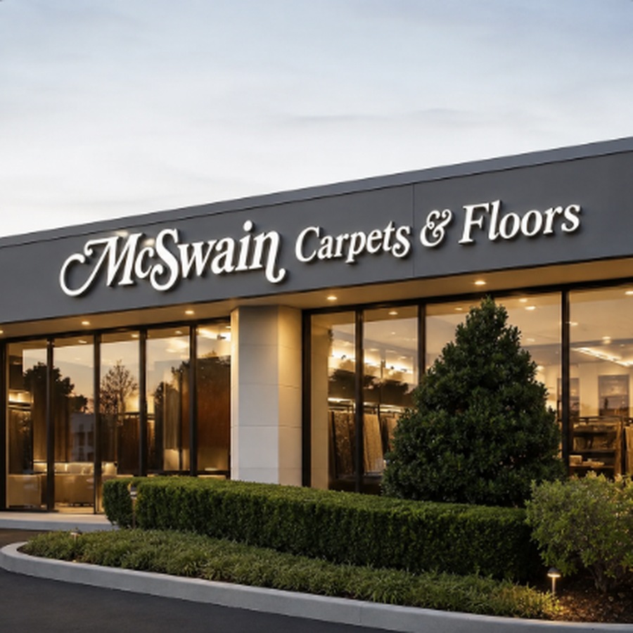Illuminated flooring showroom storefront at dusk with landscaped entrance | McSwain Carpets & Floors