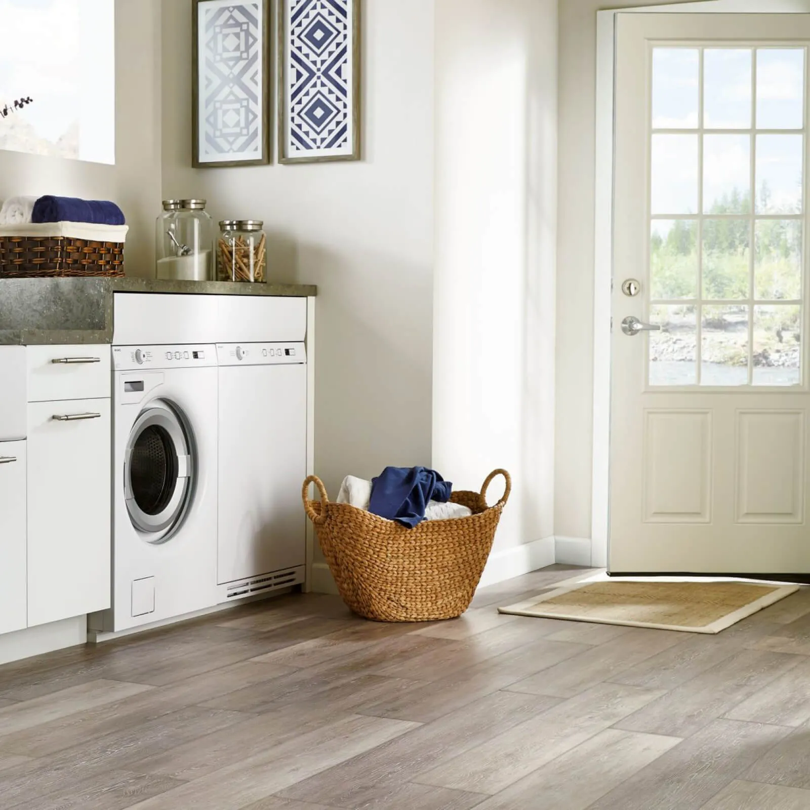 Light gray wood-look luxury vinyl tile flooring in a laundry room | McSwain Carpets & Floors