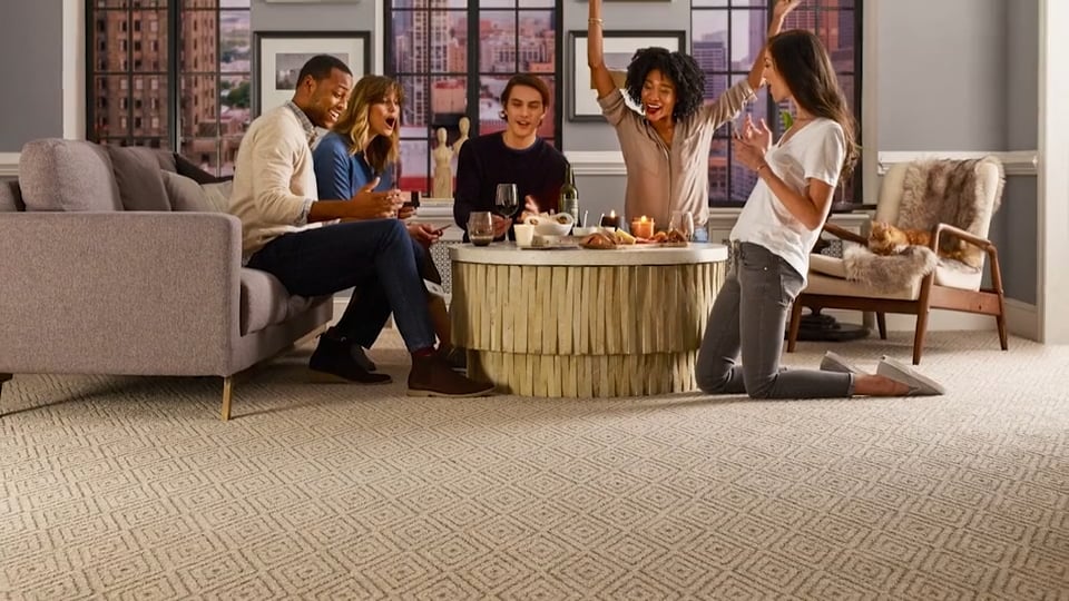 Friends gathered in a living room with patterned carpet | McSwain Carpets & Floors